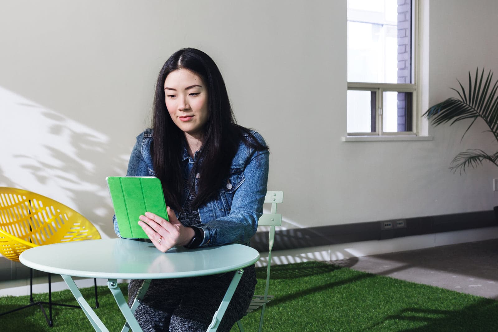 woman reading a tablet outdoors at a table