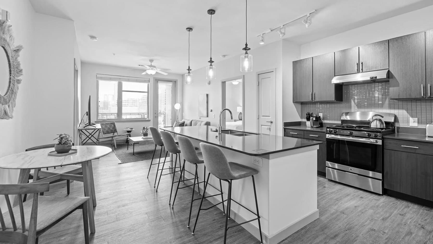 Black-and-white photo of a modern Placemakr apartment kitchen and living area