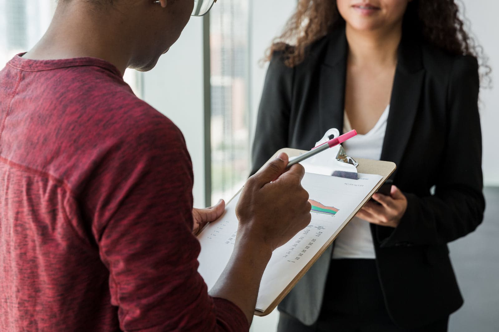colleagues reviewing a clipboard in an office