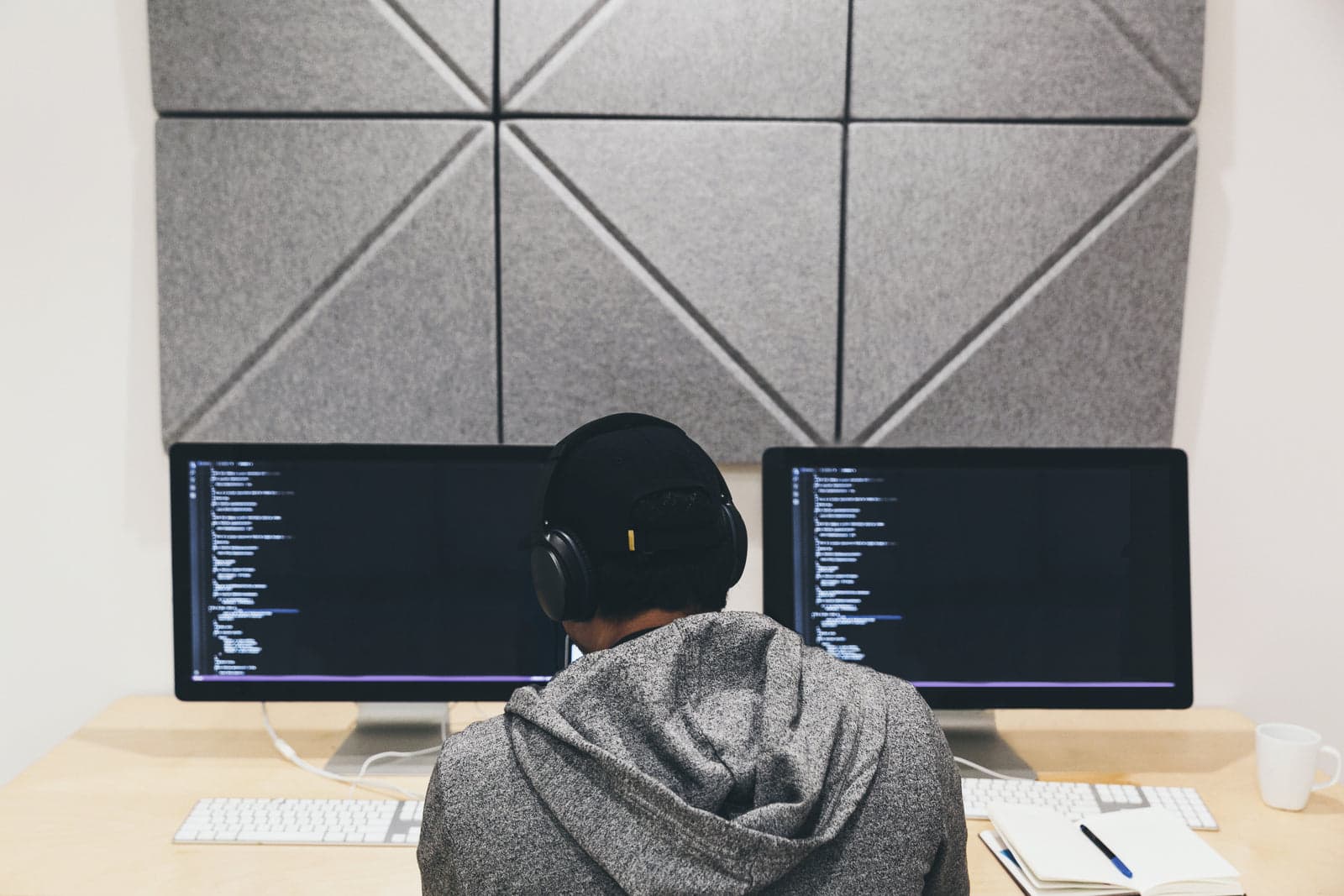 developer working at dual code-filled monitors