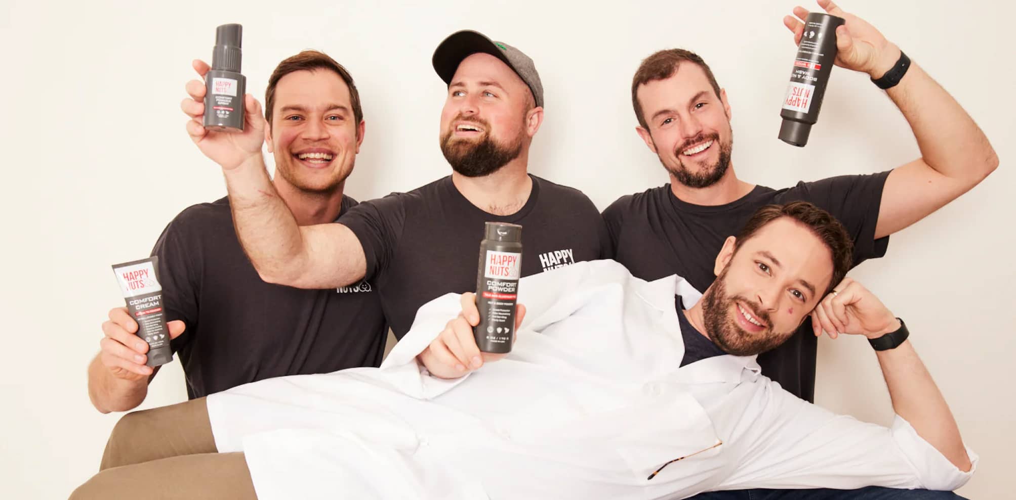Happy Nuts team holding products against a white backdrop