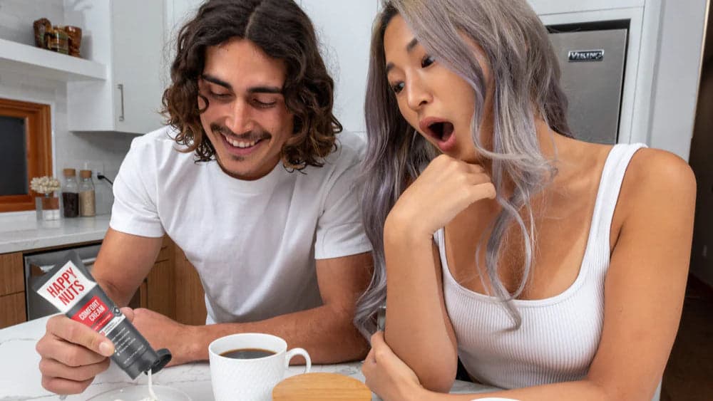 Couple reacting to a Happy Nuts product at a kitchen table