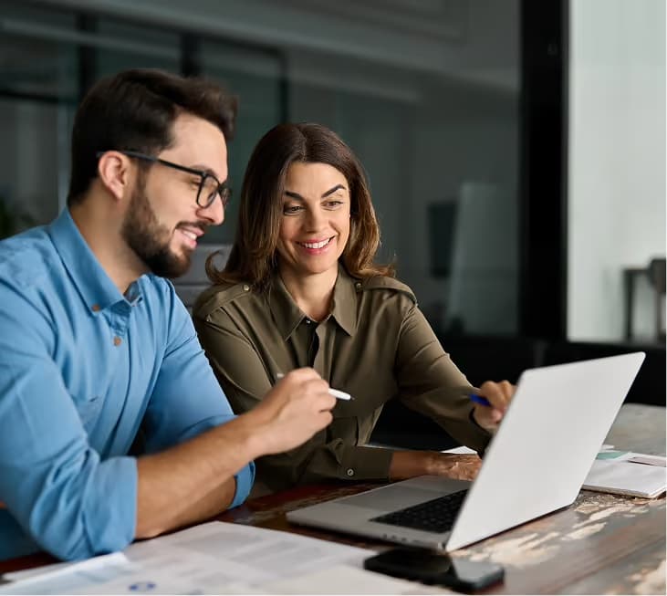 Two colleagues collaborating over a laptop